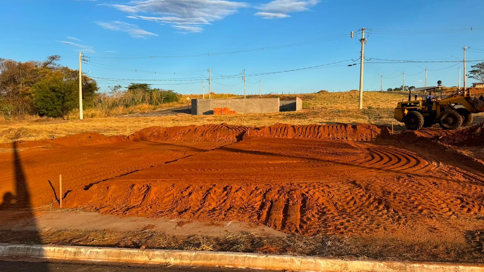 Terreno nivelado pela D.A. TERRA com pá carregadeira ao fundo, em Votuporanga